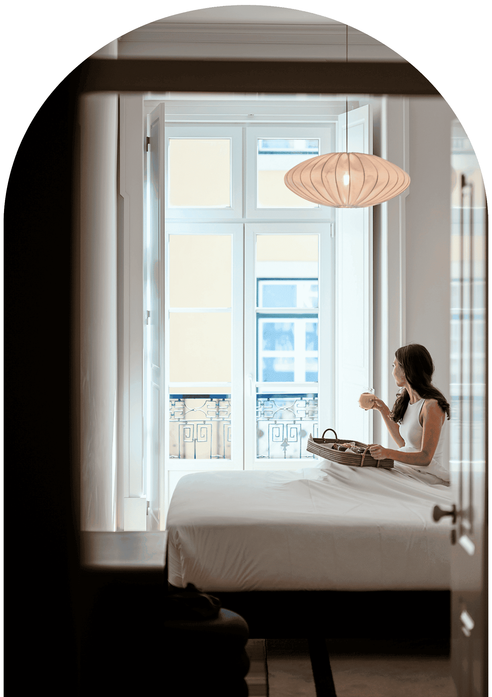Ando Living Book Direct Benefits. Cozy bedroom with a guest enjoying breakfast by open windows, sunlight streaming in, creating a serene atmosphere.