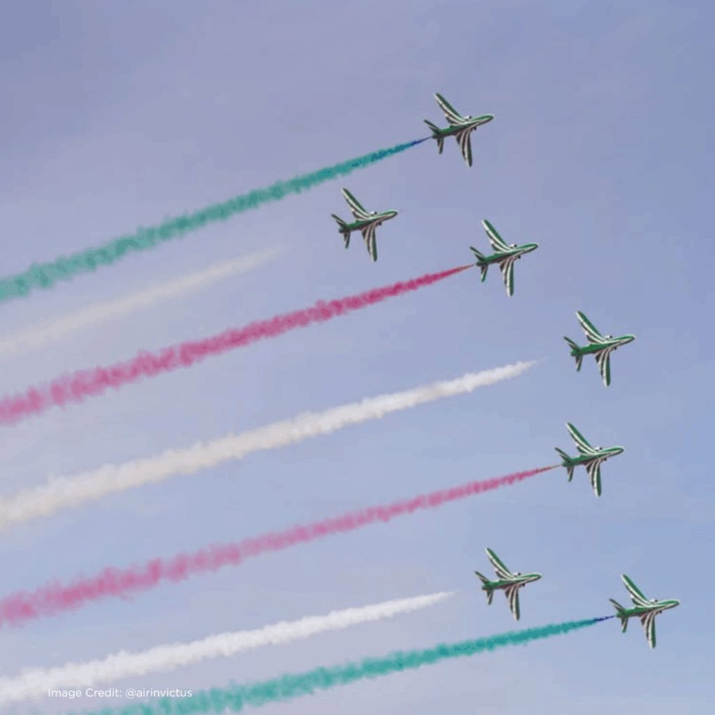 Formation flying jets create colorful smoke trails in the sky, showcasing aerial artistry and precision flight maneuvers.