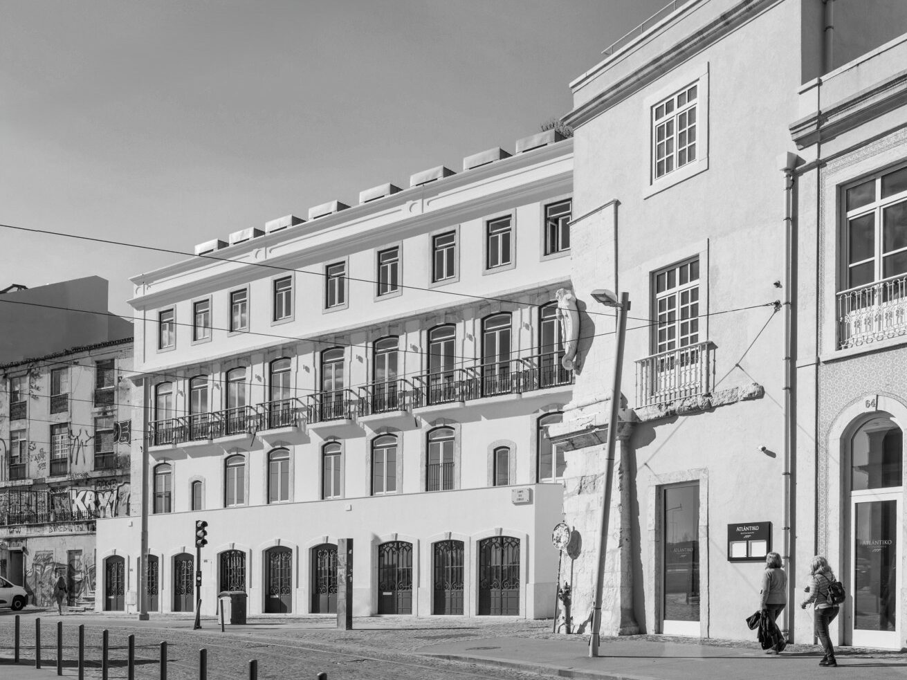 Black and white image of urban architecture showcasing elegant buildings and pedestrians on a city street.