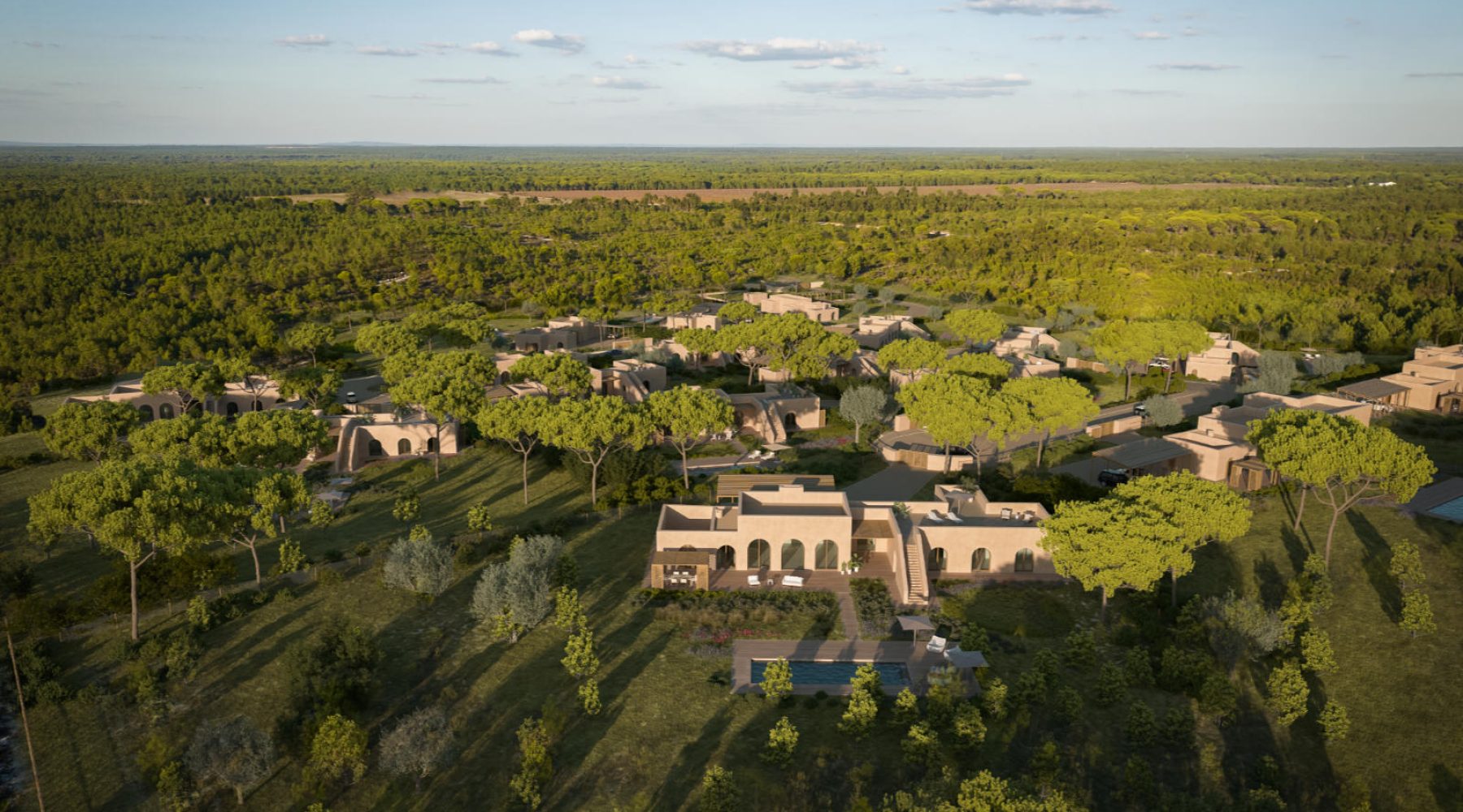 Aerial view of a luxury resort nestled in lush greenery and natural landscape under a clear blue sky.