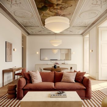 Elegant living room with ornate ceiling, modern furniture, red sofa, and geometric rug, creating a cozy, luxurious ambiance.