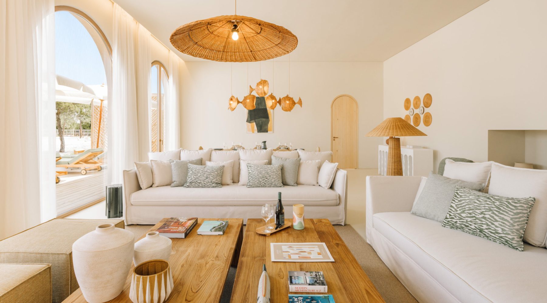 Ando Living Comporta Villas. Bright and airy living room with stylish decor, featuring cozy sofas, wooden coffee table, and unique lighting.