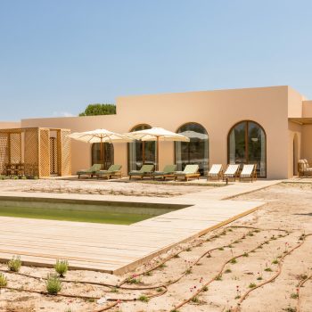 Ando Living Comporta Villas. Modern vacation home with pool, sun loungers, and shaded seating area in a serene outdoor setting. Perfect for relaxing.