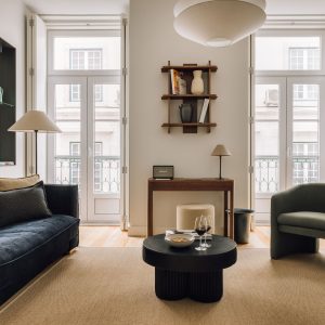 Modern living room with cozy seating, round coffee table, and natural light from large windows.