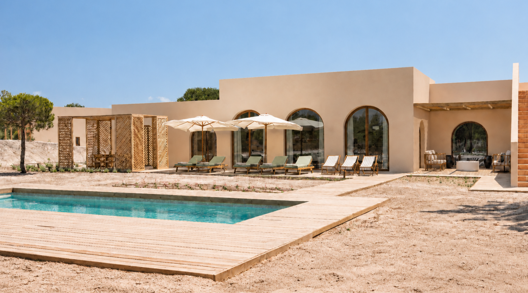 Modern villa with a pool, wooden deck, and shaded lounge chairs in a serene outdoor setting under a clear blue sky.
