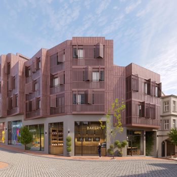 Modern urban building with brown facade, street shops, and people walking on a sunny day.